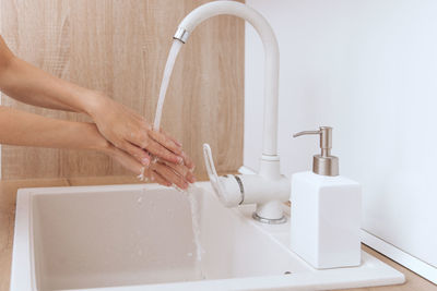 Cropped hands washing sink