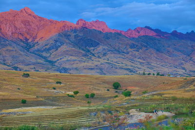 Scenic view of field and mountains against sky