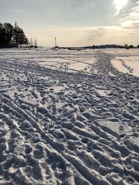 Scenic view of frozen landscape against sky at sunset