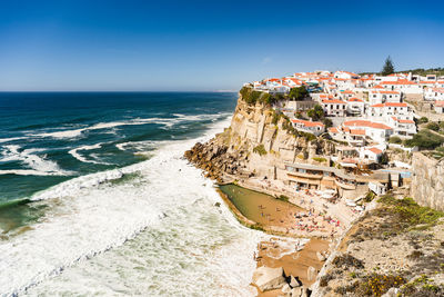 Town at beach against clear blue sky