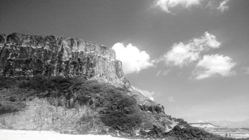 Rock formations in sea against sky