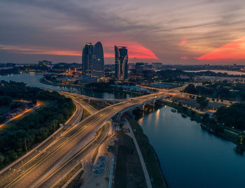 High angle view of city lit up at sunset