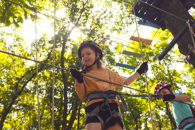 Portrait of young woman standing against trees