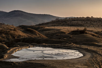 Mud volcano in autumn at sunset.