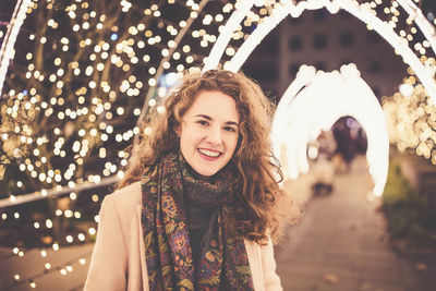 Girl outdoors, christmas lights in the background