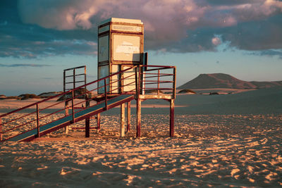 Lifeguard hut on beach against sky