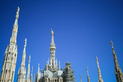 Low angle view of duomo di milano against clear blue sky