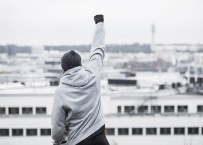 Sporty man celebrating success against buildings