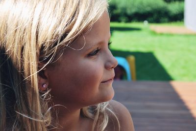 Close-up of girl looking away in yard