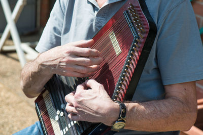 Midsection of man playing guitar