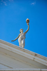 Low angle view of statue against blue sky