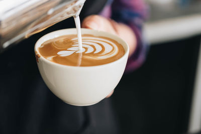 Midsection of person preparing coffee at cafe