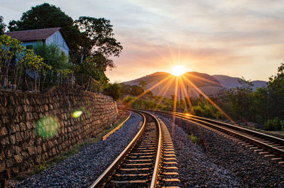 Railroad tracks against sky during sunset