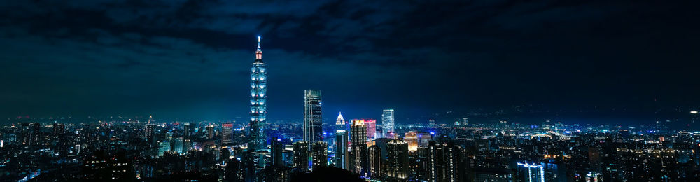 Illuminated buildings against sky at night