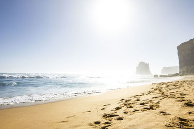 Scenic view of beach against clear sky on sunny day