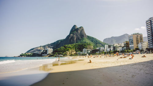 People at beach against clear sky