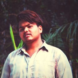 Portrait of young man standing in forest