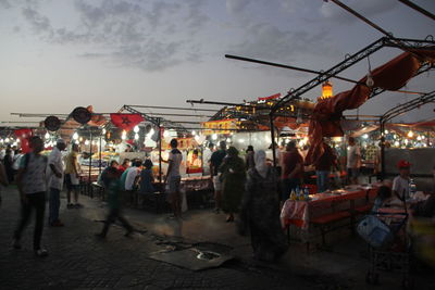 Crowd in city against sky at night