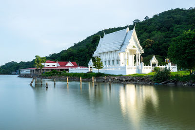 Building by lake against sky