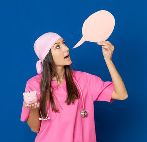 Woman standing against pink blue background