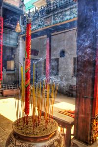 Illuminated candles on temple outside building