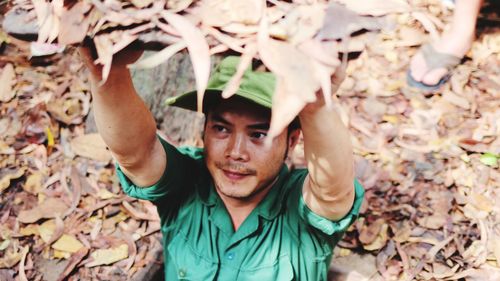 Portrait of young man with dry leaves