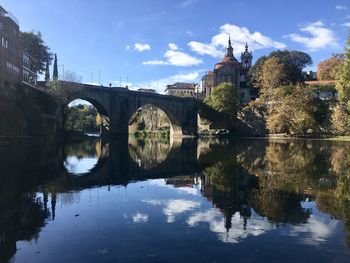 Arch bridge over river against buildings