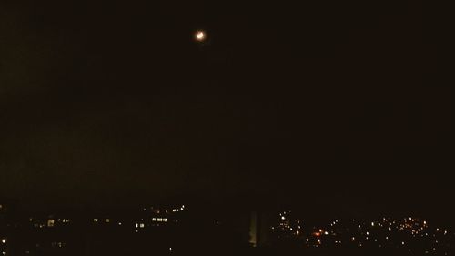 Illuminated cityscape against sky at night