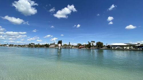 Scenic view of sea by buildings against sky