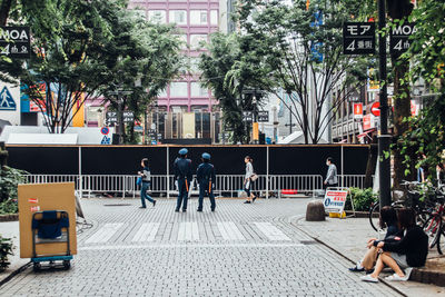 View of people on pedestrian walkway in city