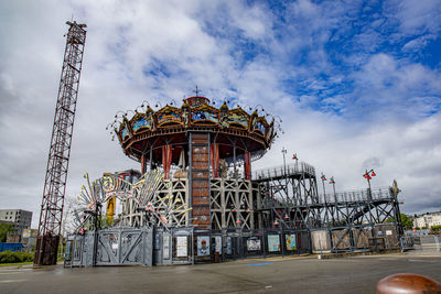 View of amusement park against cloudy sky