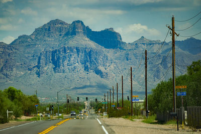 Road by mountains against sky