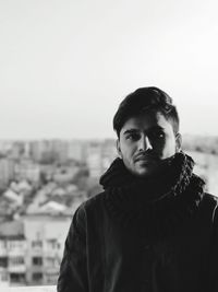 Portrait of young man standing in city during winter