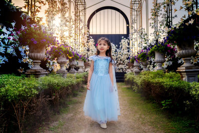 Young cute asian girl with blue dress are relaxing in the flower park