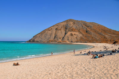 Scenic view of beach against clear blue sky