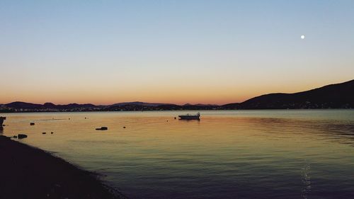 Boats in sea at sunset