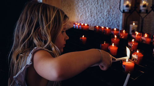 Close-up of girl holding illuminated candles