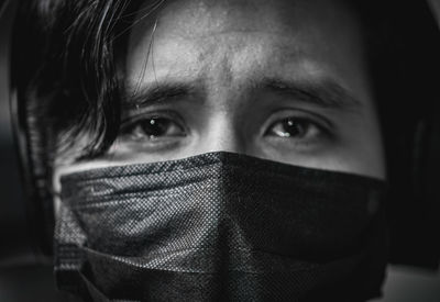 Close-up portrait of teenage boy covering face