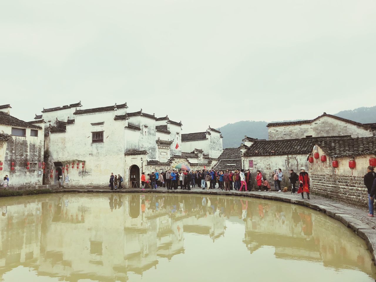 GROUP OF PEOPLE IN FRONT OF BUILDINGS AGAINST SKY