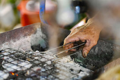 Person preparing food on barbecue grill