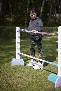 Boy adjusting hurdle at racing competition