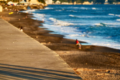 Man walking on beach during sunset