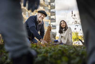 Group of neighbors gardening together in courtyard