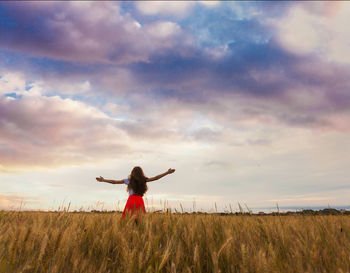 Full length of woman standing on field against sky