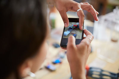 Close-up of woman photographing with mobile phone