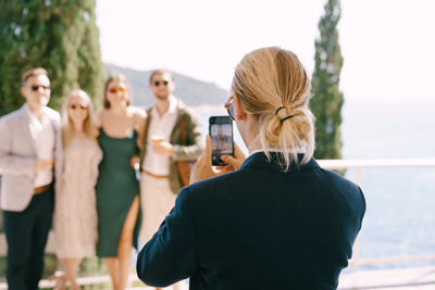 Rear view of women standing against blurred background