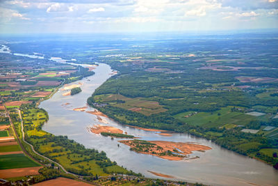 Aerial view of river amidst field against sky
