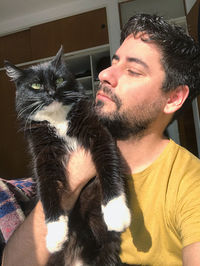 Young man with cat at home