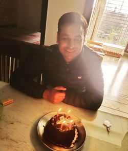 Reflection of boy sitting on table at home