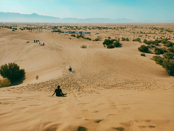 Rear view of people on sand dune